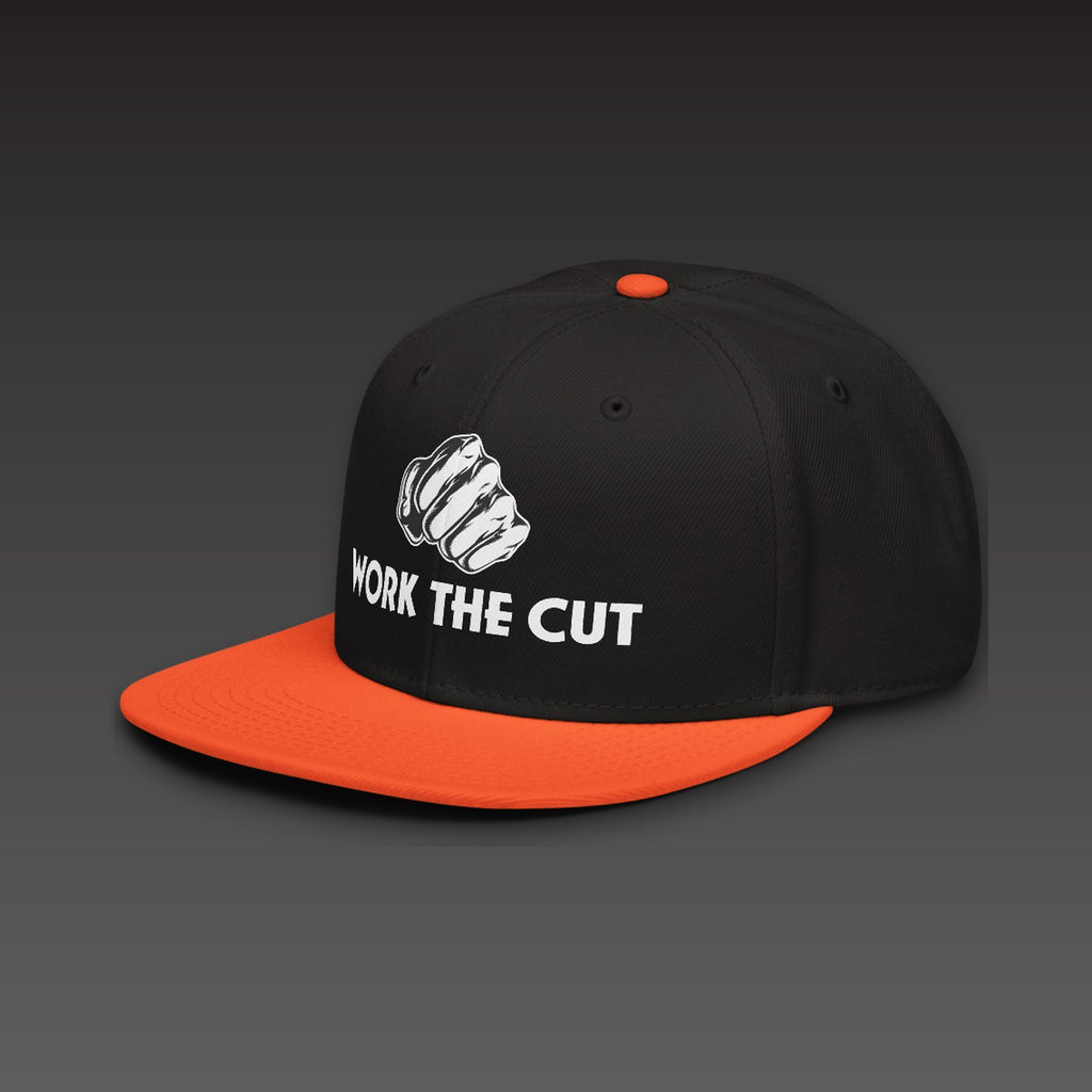 OG Fist Flat Bill in orange visor, the fist over WORK THE CUT in white type, printed on the front, seen from the side