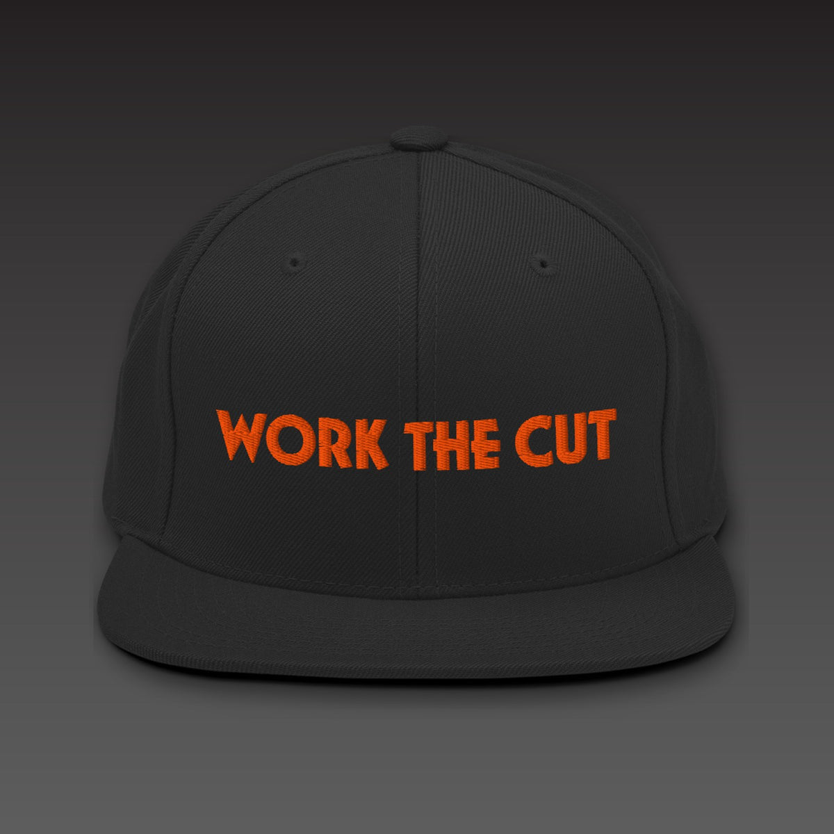 One-Line Flat Bill in black / orange, WORK THE CUT in one line of orange embroidery across the front