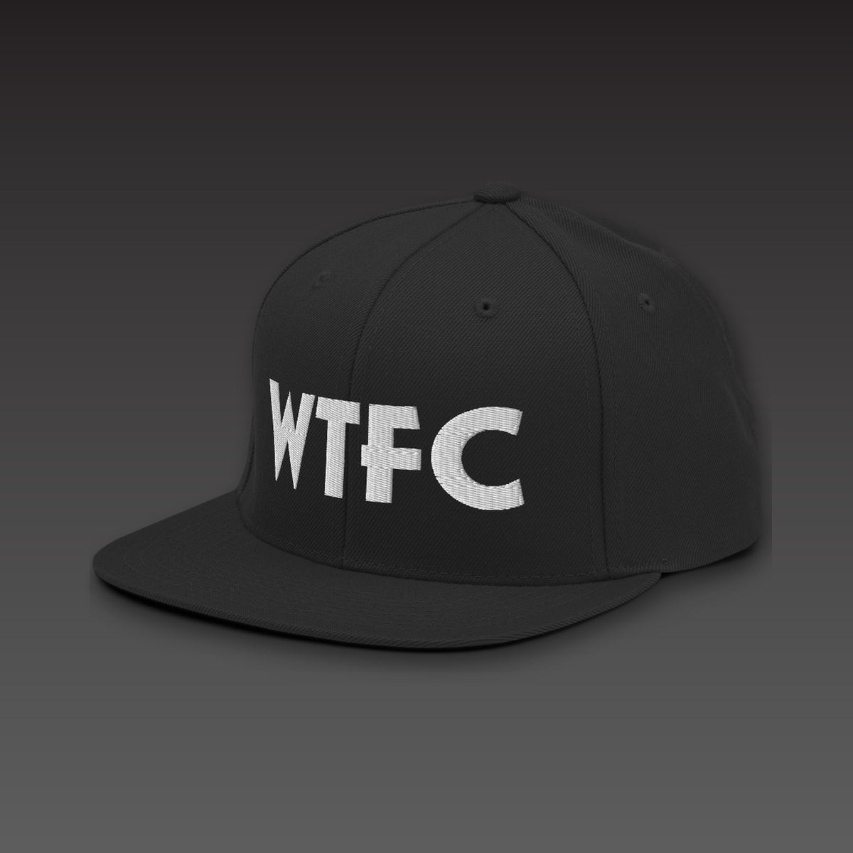 Puff Snapback in black / white, WTFC in white 3D puff embroidery on the front, seen from the side