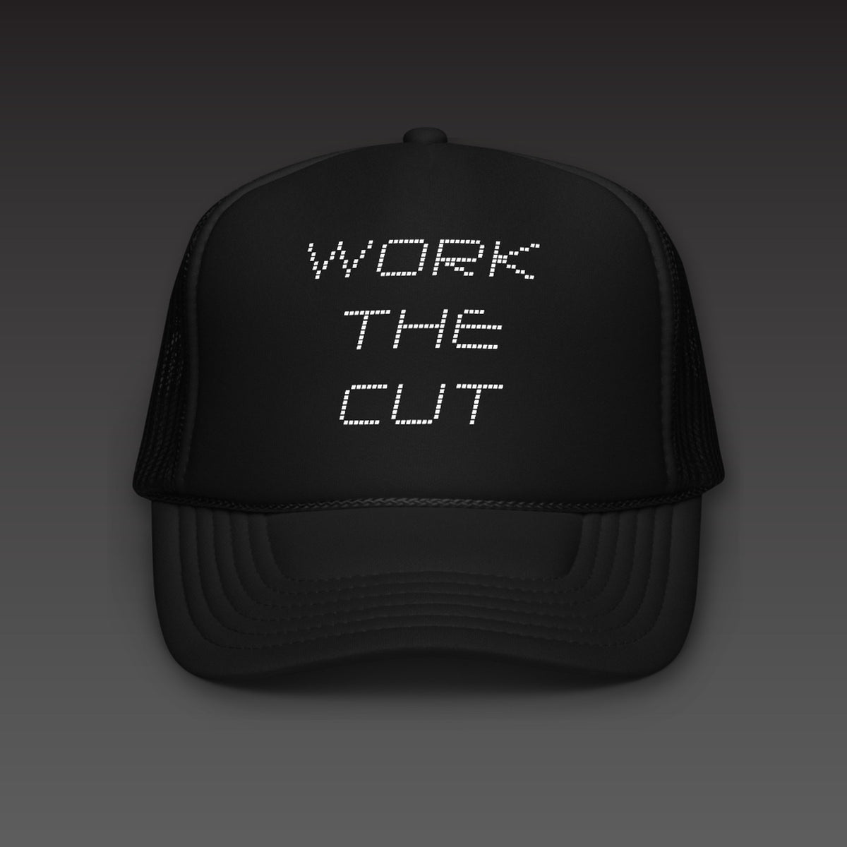 Scoreboard Trucker in black, WORK THE CUT stacked in white scoreboard dots on the front
